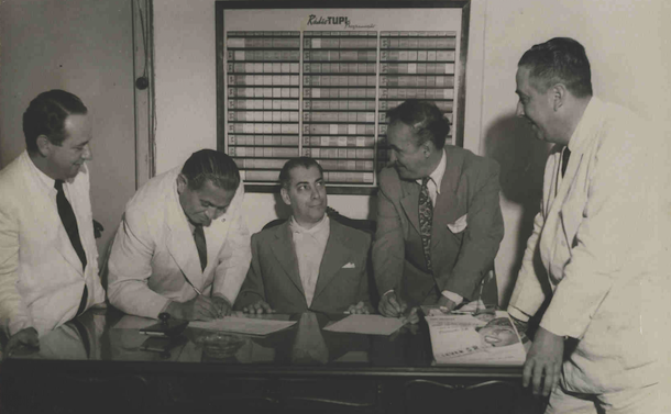 Ratinho está assinando o contrato à direita, Almirante ao centro e Jararaca à esquerda na Rádio Tupi